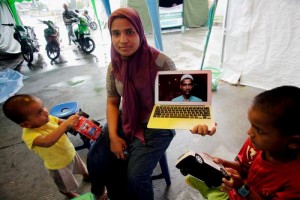 فاطمة تعرض صورة زوجها حسان المتواجد في كوانتان في ماليزيا. 