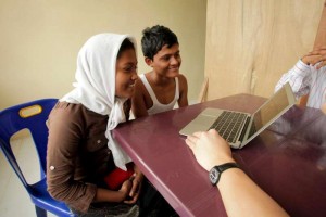 في آتشيه في أندونيسيا، يعرض موظف المفوضية على علي، الذي يبلغ من العمر 18 عاماً، وشهيدة التي تبلغ من العمر 14 عاماً، صورة والدتهما وشقيقهما الأصغر في ماليزيا. 